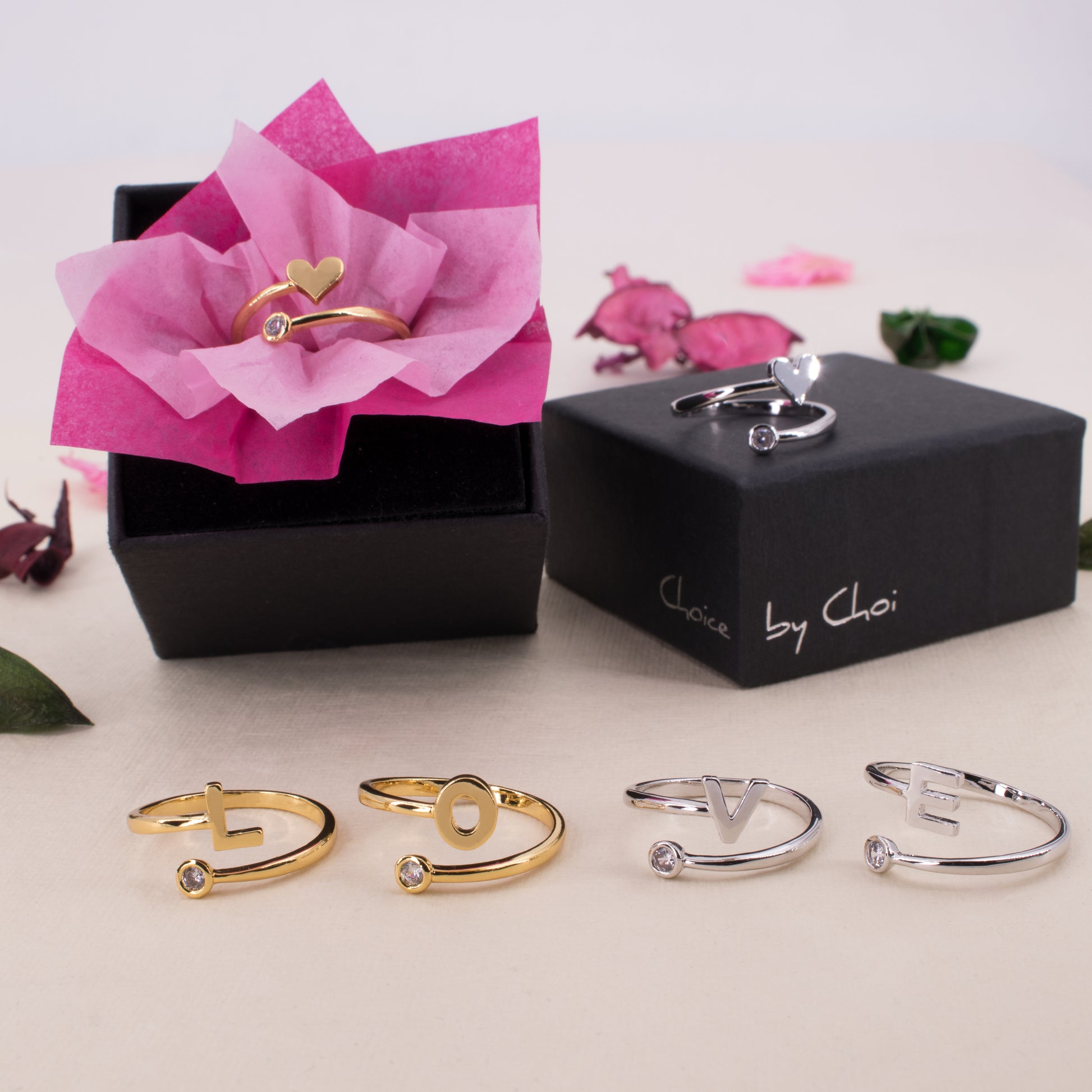 adjustable zirconia rings in, out and in front of boxes with flower petals in background